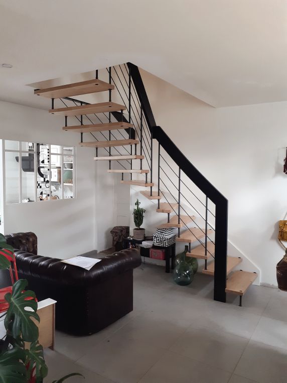 Escalier suspendu bois métal marches en bois rampe à balustres métalliques en noir